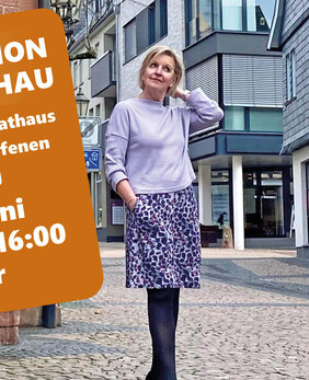 Frau posiert in Fußgängerzone im Rahmen einer Modenschau